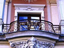 Кованые перила для ограждения балкона оригинальной формы. Рисунок выполнен в сочетании ажурной сетки с цветами на пересечении, кованых листьев и цветов в центре №103
